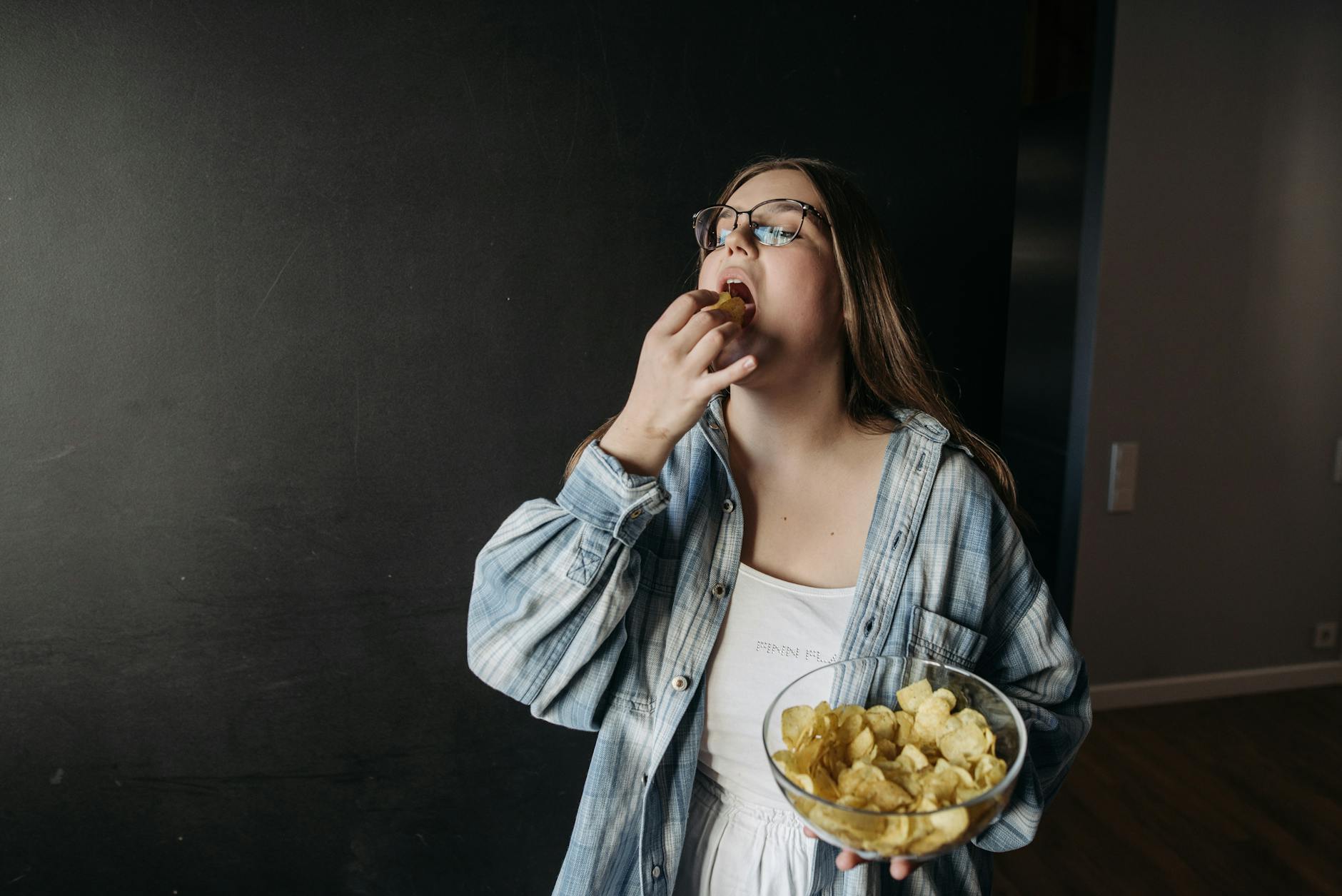 woman standing with a bowl of chips